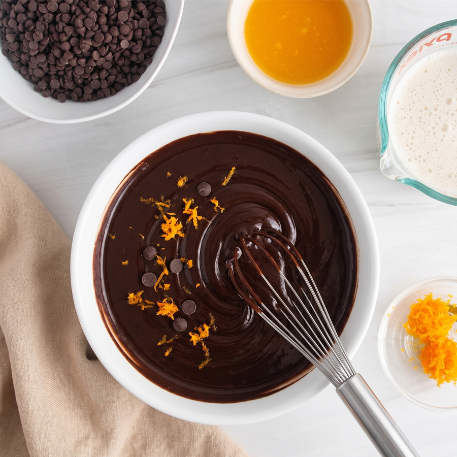 Ingredients for chocolate orange ganache including chocolate, cream, and orange zest