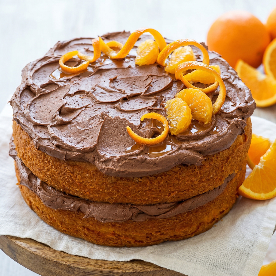 A slice of orange velvet cake with thick frosting on a plate